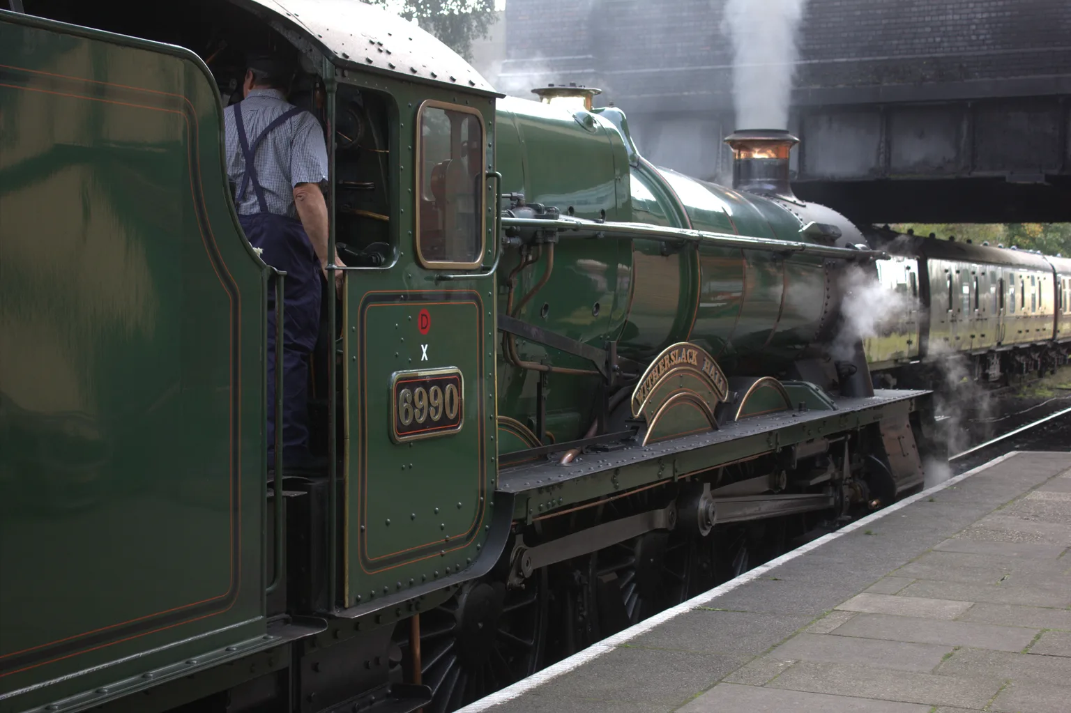 A green Great Western steam locomotive standing at Loughborough Central with its crew on the footplate