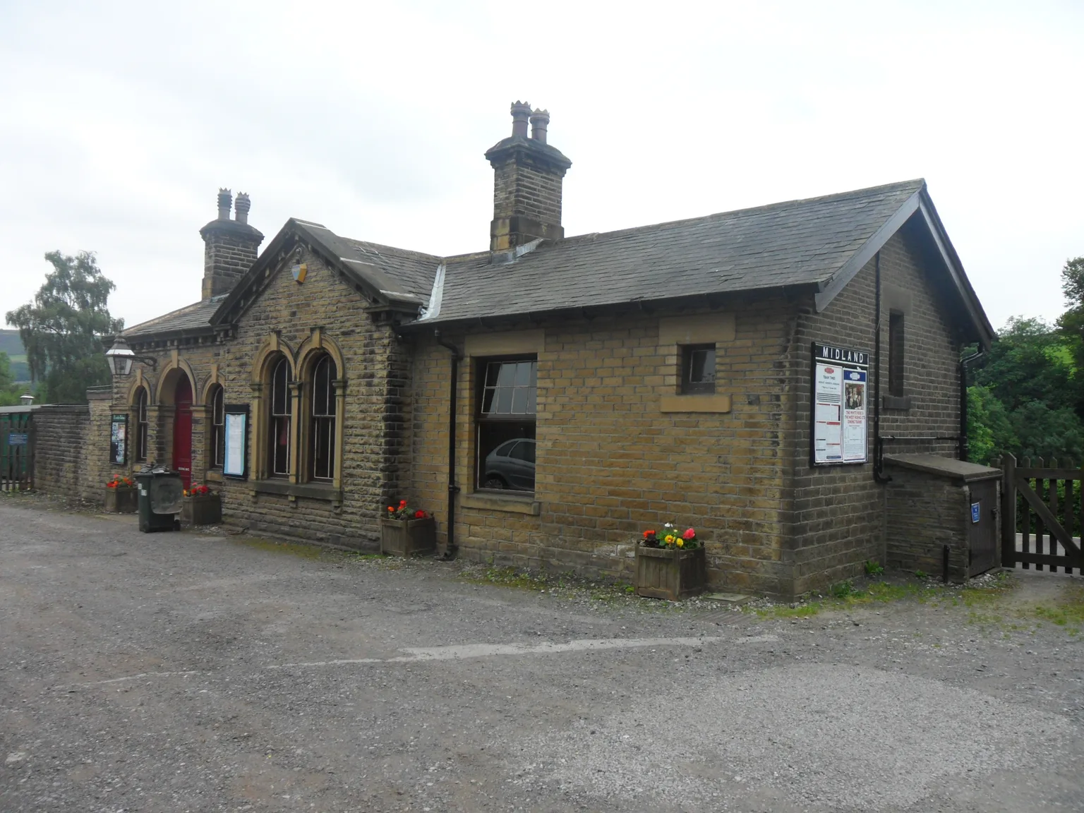 The small stone station building at Oakworth with arched windows and flower tubs