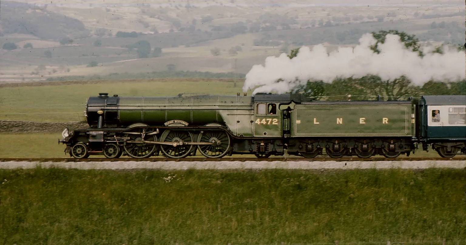 Flying Scotsman in apple green, numbered 4472 with LNER on the tender, steaming across open country with a plume of white smoke