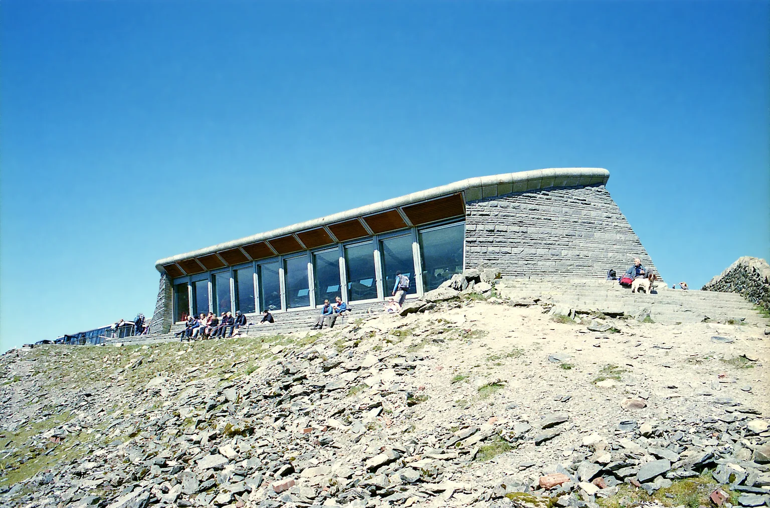 The stone and glass summit building of Hafod Eryri under a clear blue sky